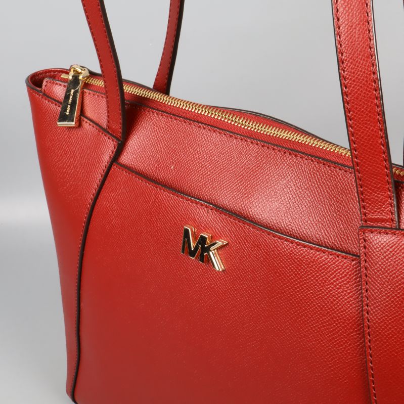 Närbild på övre delen med MK-logo och gulddragkedja