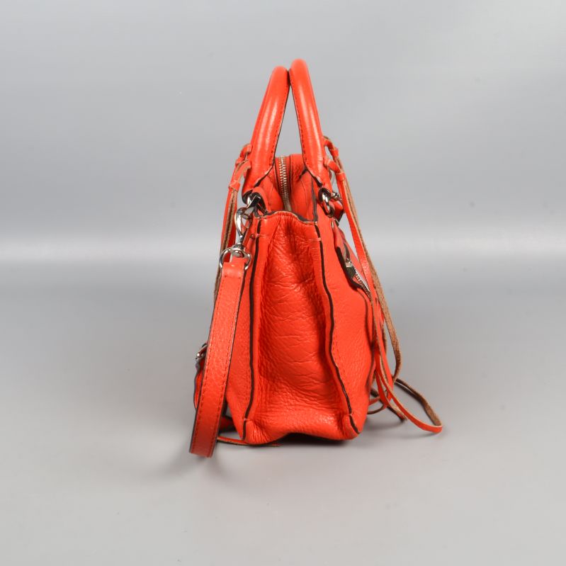 Röd väska sedd från sidan med justerbar rem