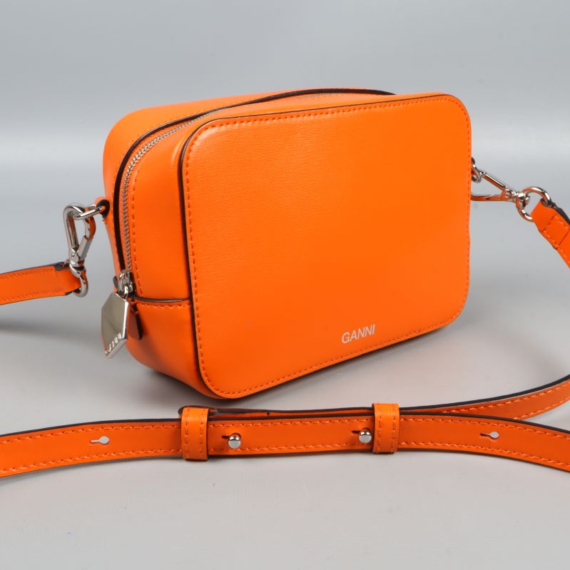 Närbild på orange väska och silverdetaljer