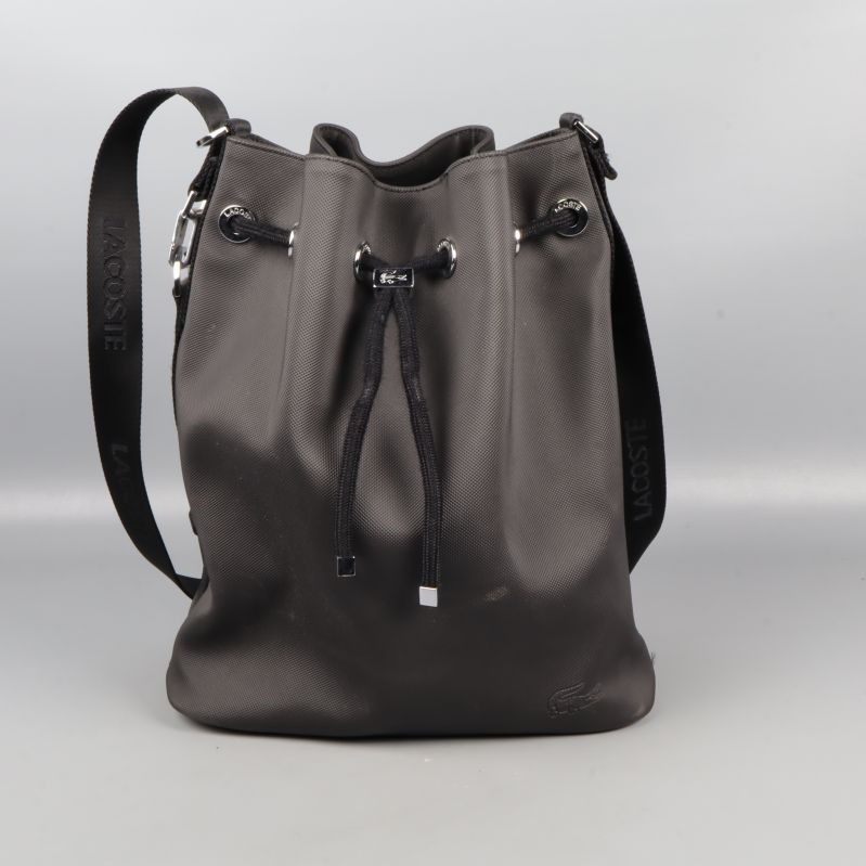 Framifrån av svart bucketbag med snörning och logotyp