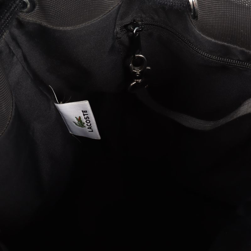 Insidan av väskan med Lacoste-etikett och dragkedja