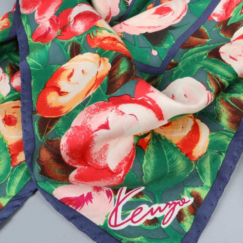 Närbild av Kenzo-logotyp och blommor på siden