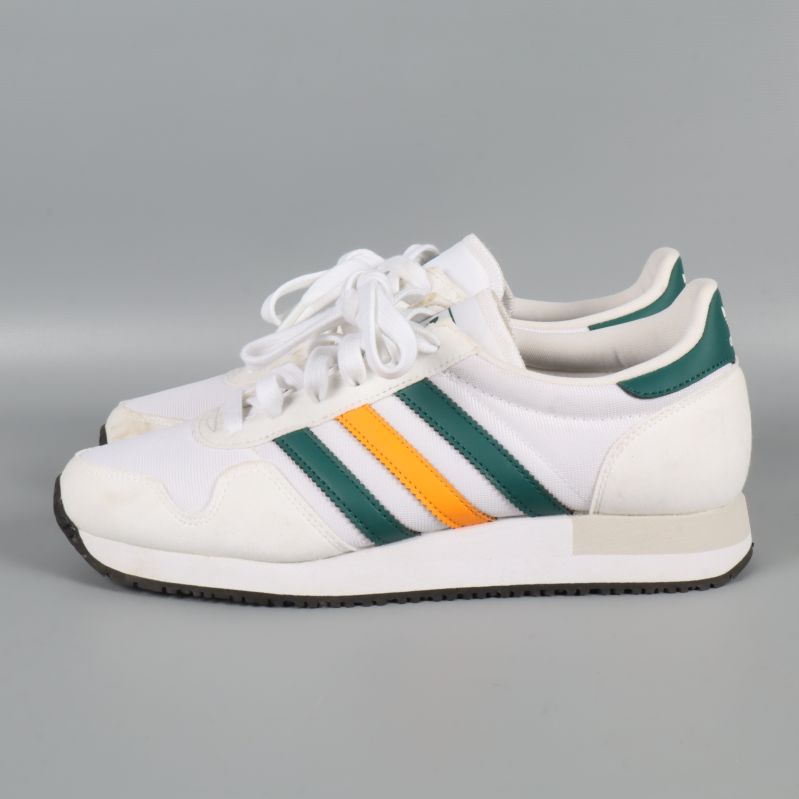 Sneakers från sidan liggande på grått underlag