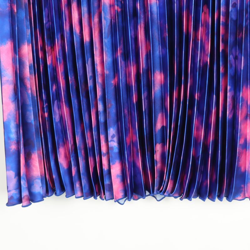 Närbild på tyg och plisserad nederkant i batikmönster