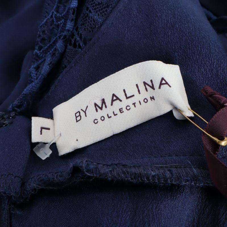 Närbild av By Malina-märkesetikett i klänningen