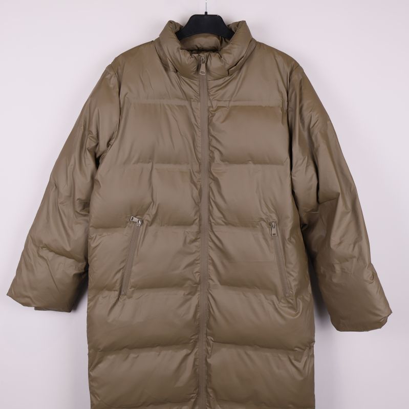 Framifrån beige lång pufferjacka med dragkedjor