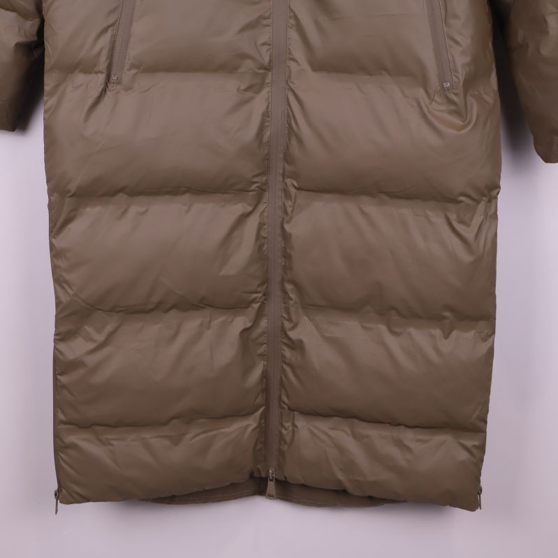 Närbild på nederkanten av beige pufferjacka