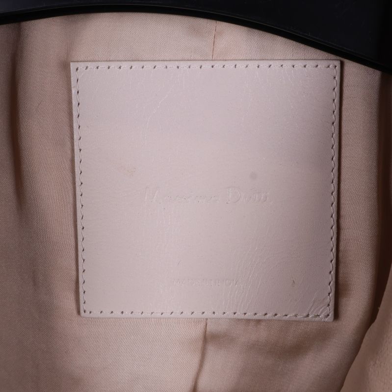Närbild på insida av beige kavaj med Massimo Dutti-label