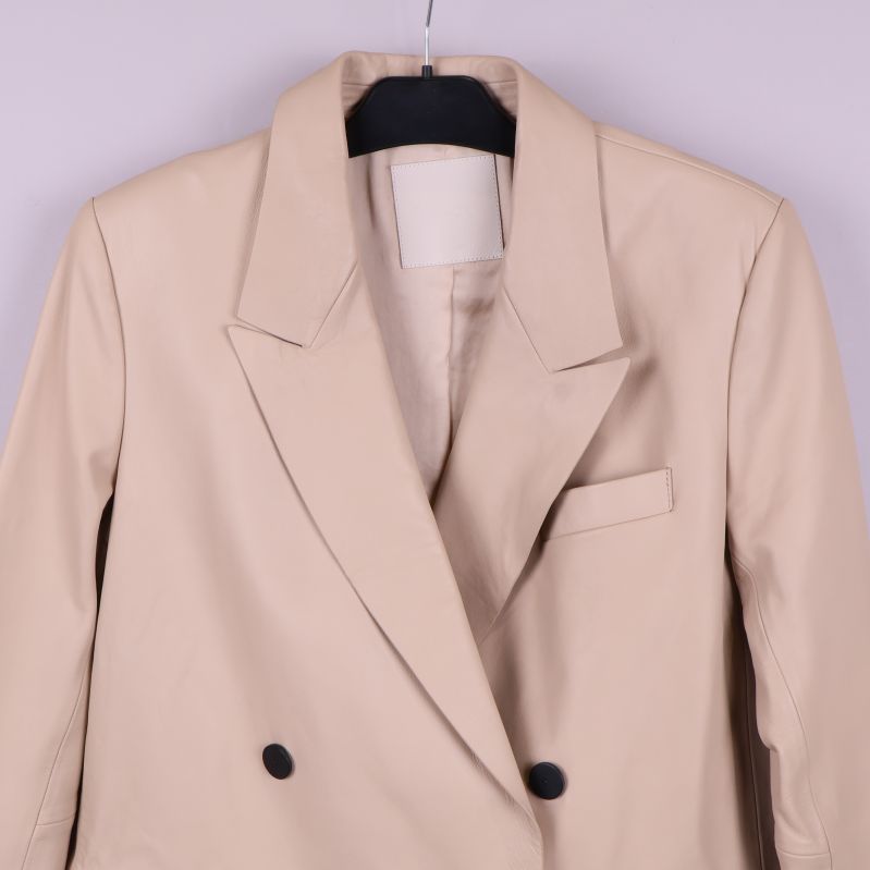 Närbild på överdelen av beige skinnkavaj med krage