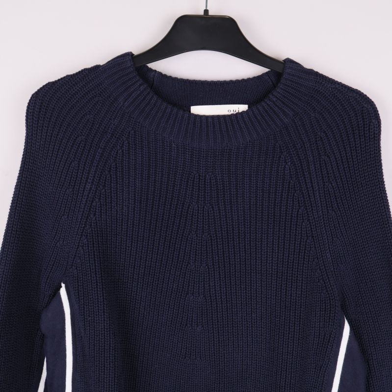 Närbild av tröjans rundhals och stickad yta