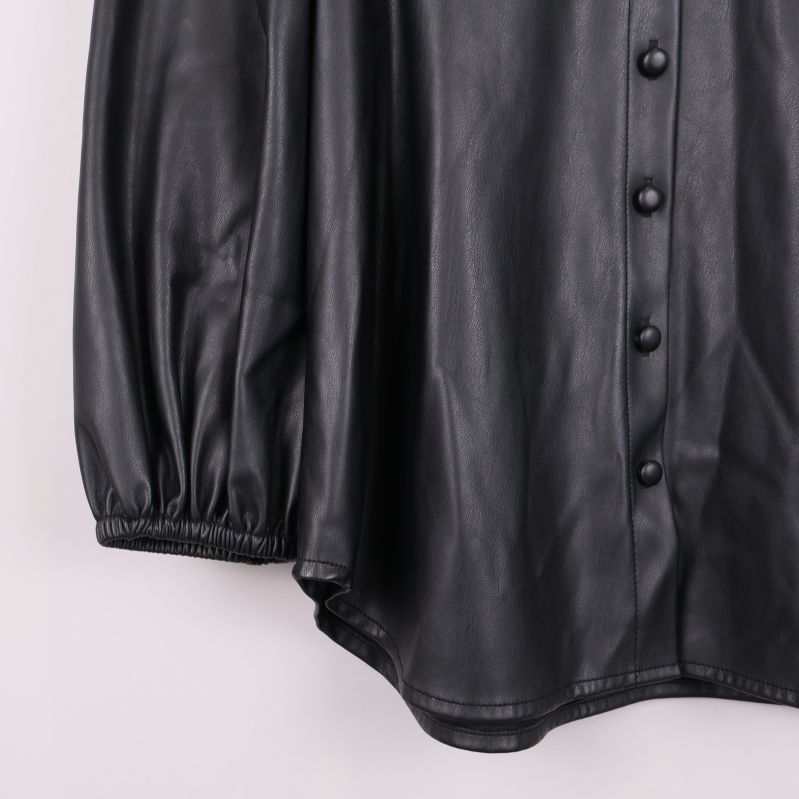 Närbild på nederkant och ärmslut av svart blus