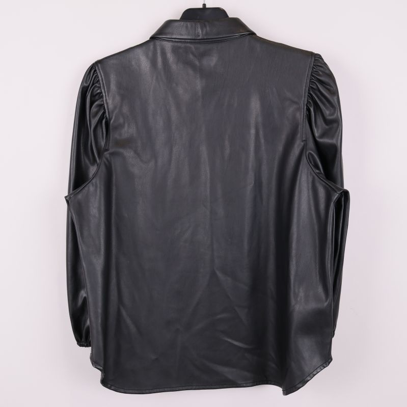 Baksida av svart blus i konstläder på galge