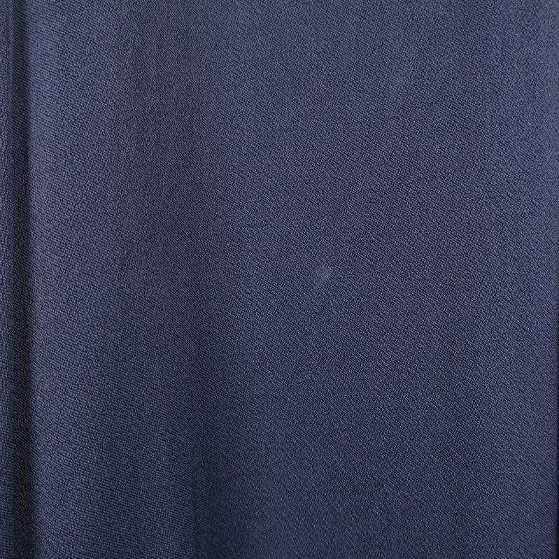 Närbild på vit fläck framtill på blå klänning