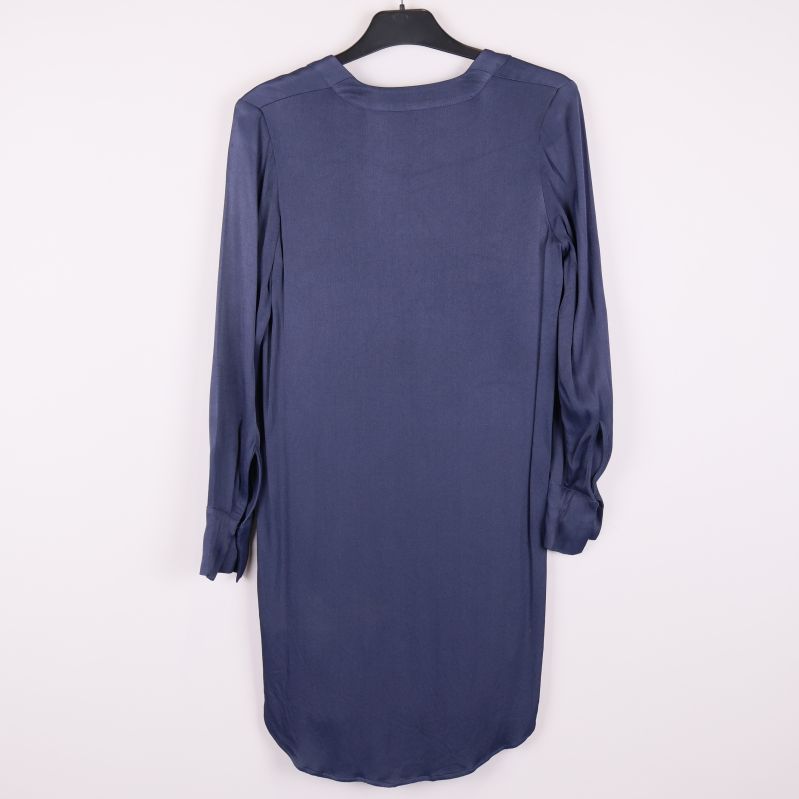 Baksidan av blå långärmad klänning visas på galge