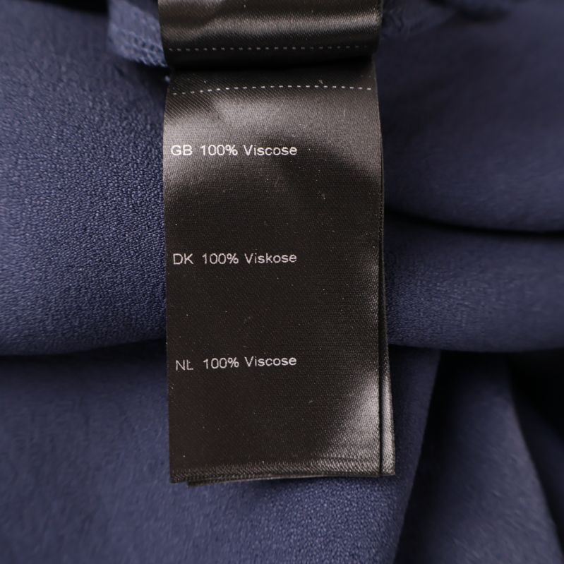 Materialetikett som visar 100% viskos på svart bakgrund