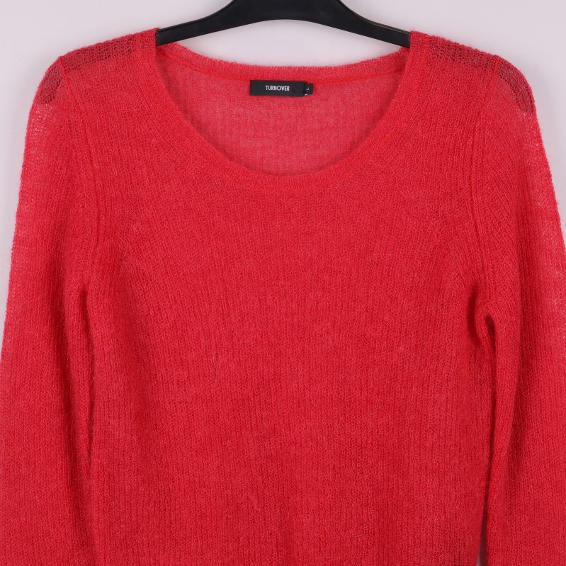 Övre del av röd stickad tröja med synlig struktur