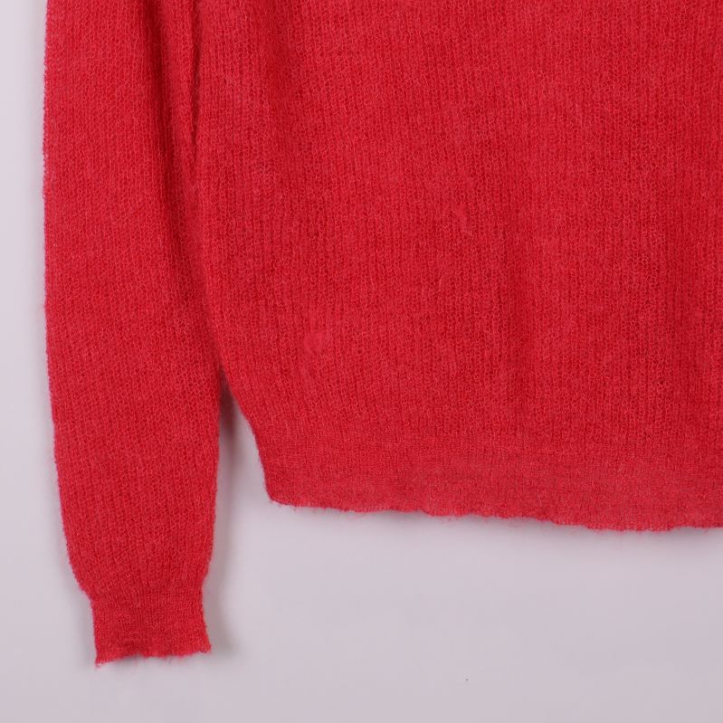 Närbild på tröjans rödstickade ärmslut och nederdel