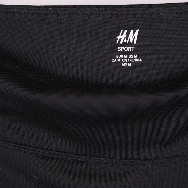 Närbild på H&M Sport logga i tightsens midja