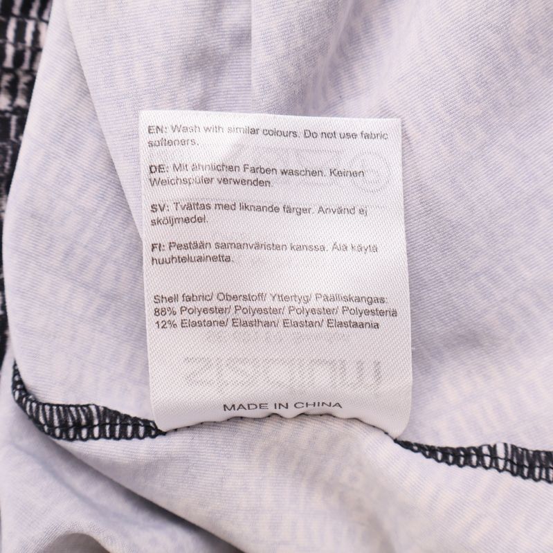 Materialetikett med information om polyester och elastan