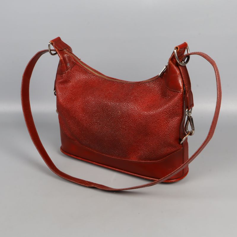 Röd axelremsväska sedd snett bakifrån med lång rem