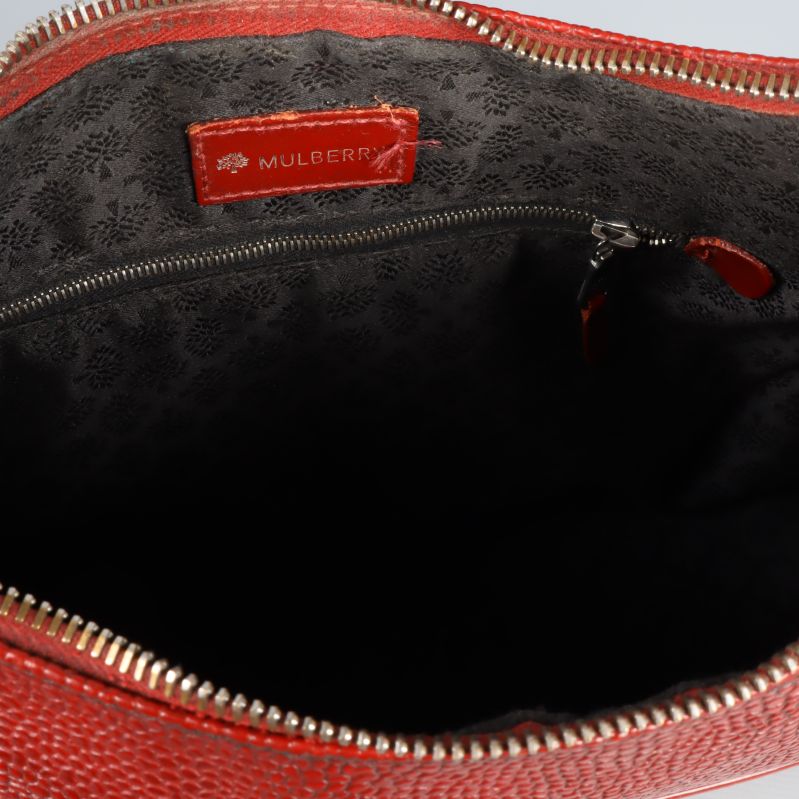 Öppen väska med svart foder och röd Mulberry-logga
