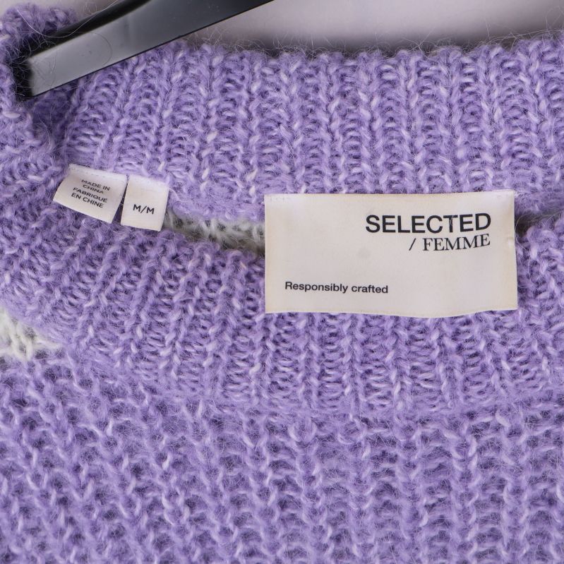 Närbild på SELECTED FEMME etikett i lila stickad tröja
