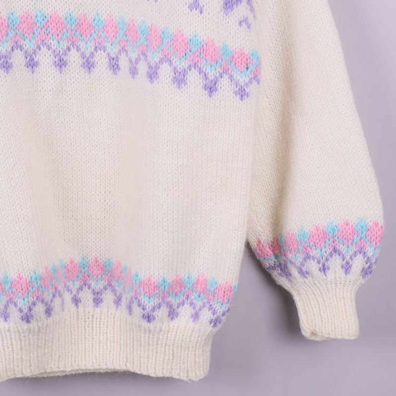 Nederkant av stickad tröja visar pastellmönster