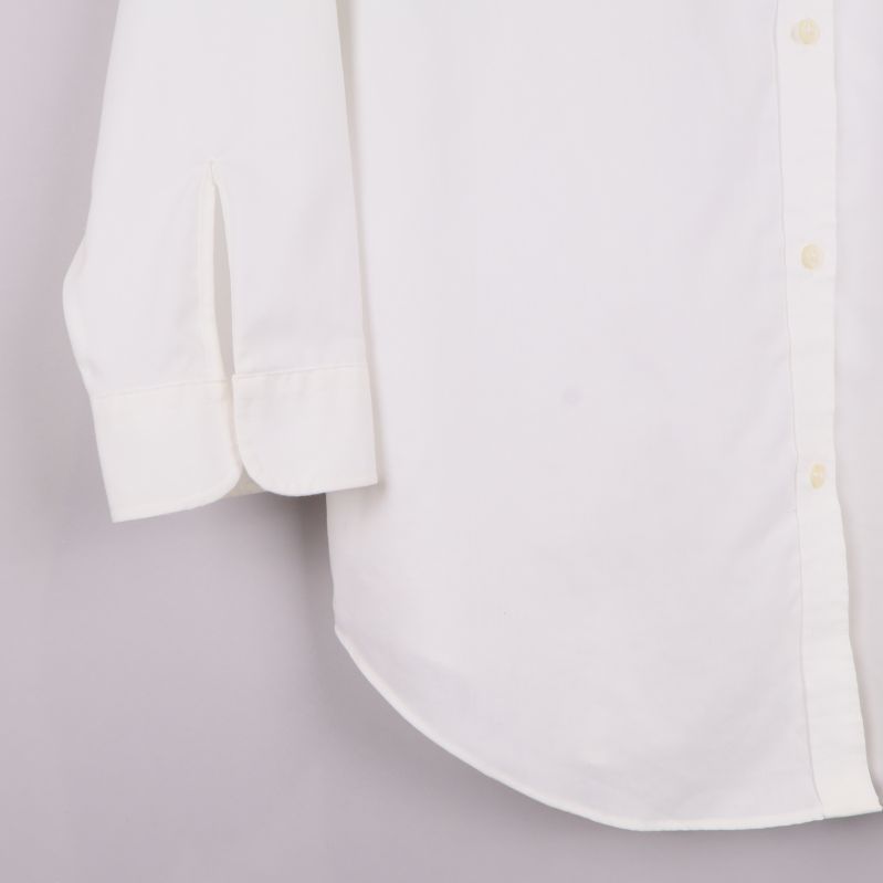 Ärmslut med manschett och knapp på vit skjorta