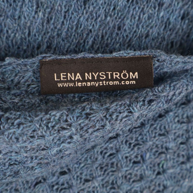 Närbild på svart etikett med Lena Nyström-text