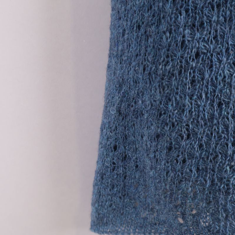 Detaljbild på blå stickad halsdukens struktur