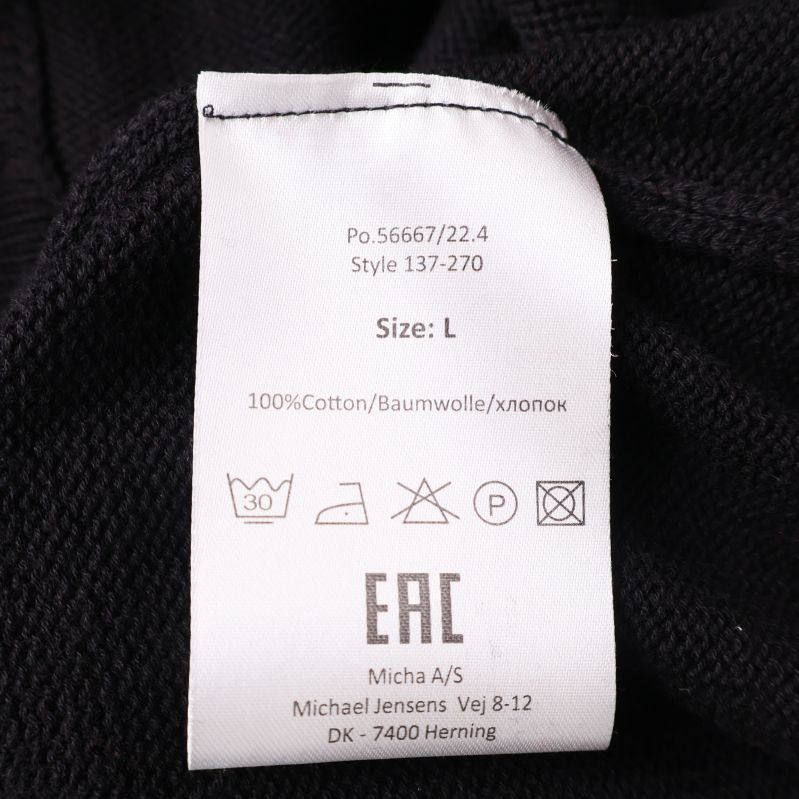 Materiallapp visar 100% bomull och tvättråd