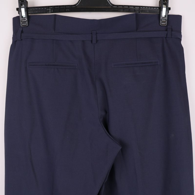 Närbild på bakfickor och midjedetaljer på byxa