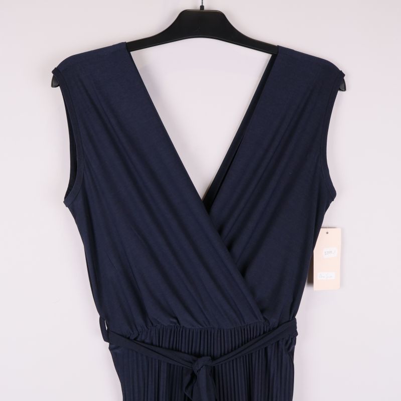 Närbild av djup v-ringning och elastisk midja på byxdress