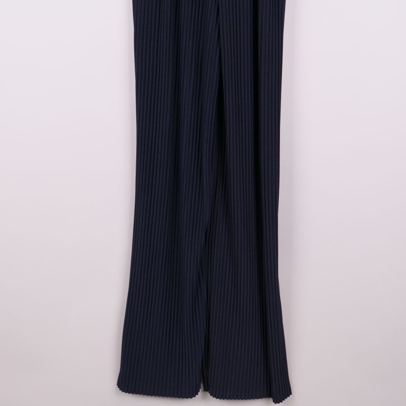 Närbild av plisserade, vida ben på byxdress