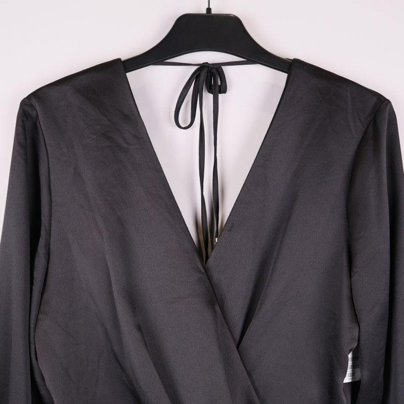 Närbild på överdelen med djup v-ringning och knytband