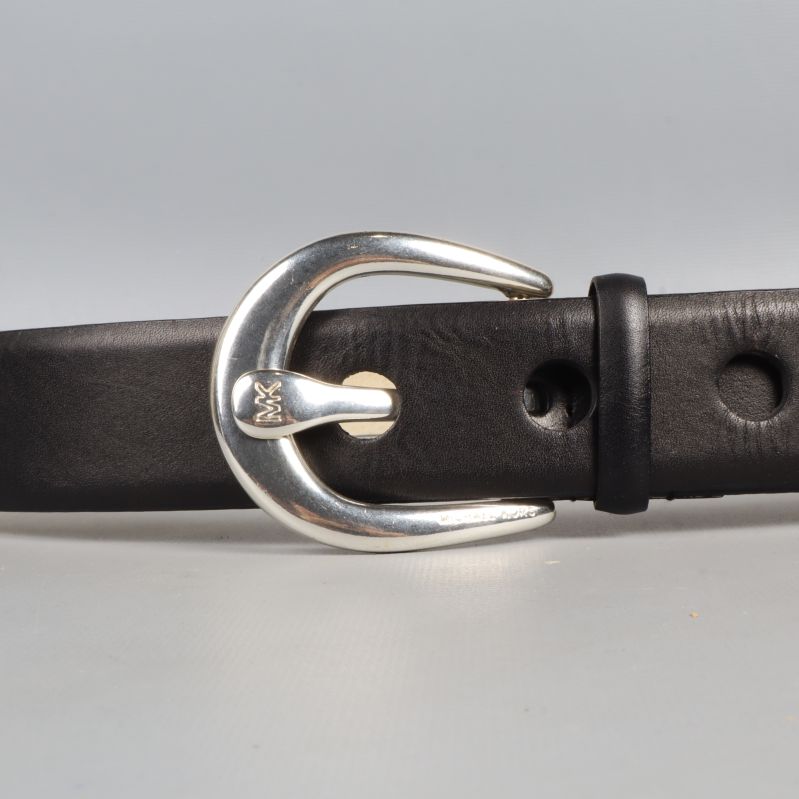 Närbild på bältets silverfärgade spänne och hål