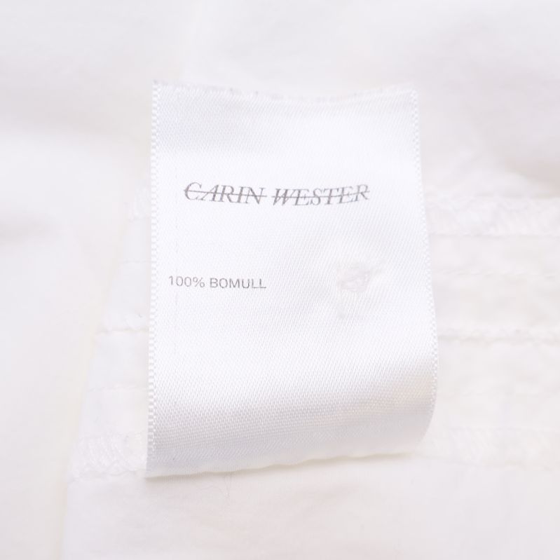 Materialetikett med texten 100% bomull Carin Wester