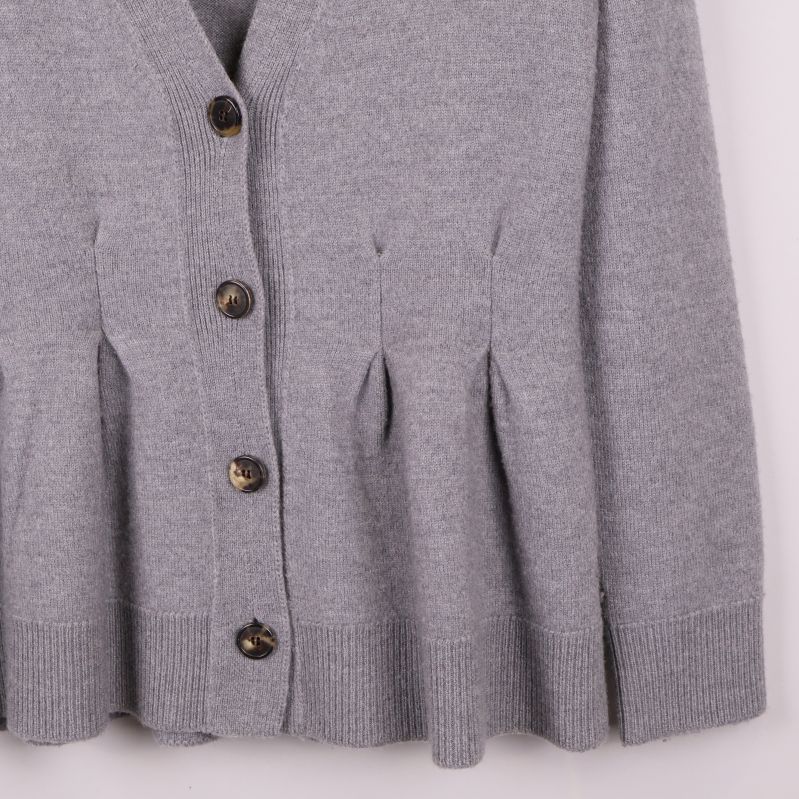 Detaljerade veck och ribbad kant på koftans nederdel