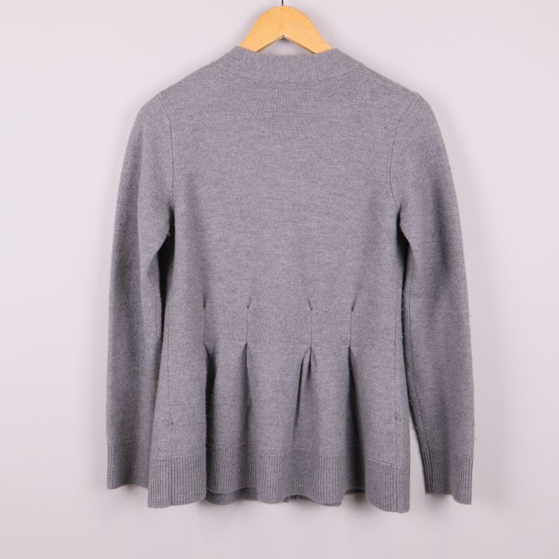 Baksidan av grå kofta med plisserad nederdel