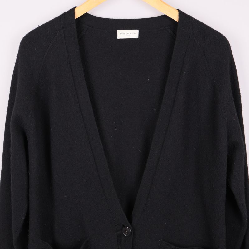 Detalj av V-ringning och knappar på svart kofta