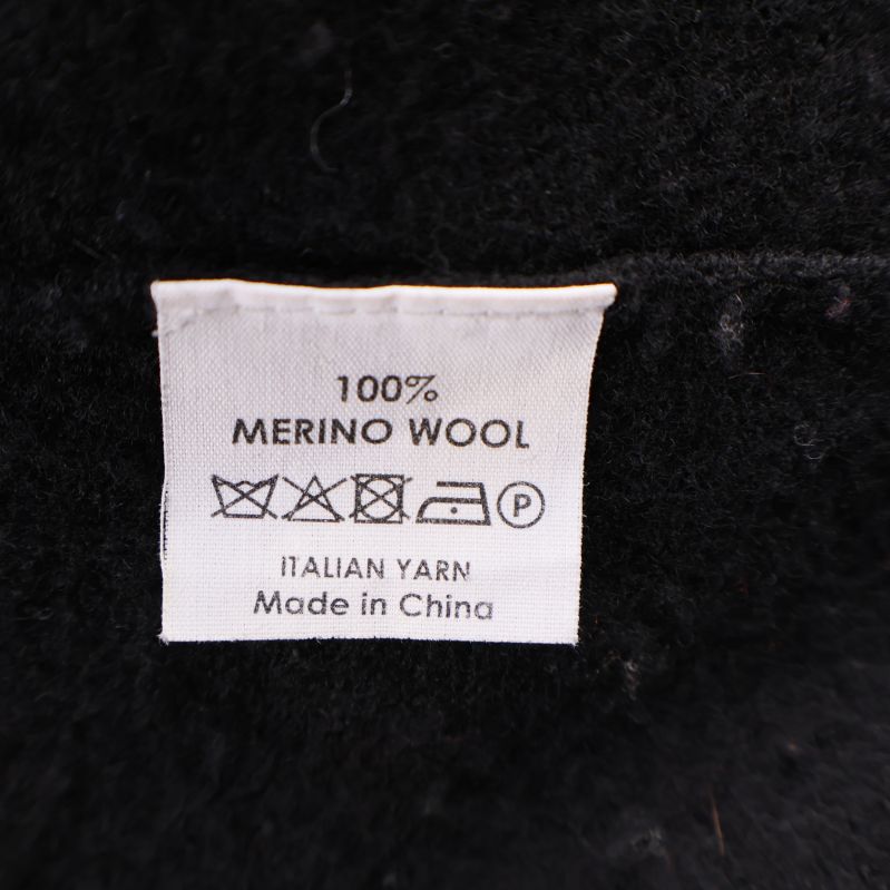 Materialetikett som visar 100% merinoull