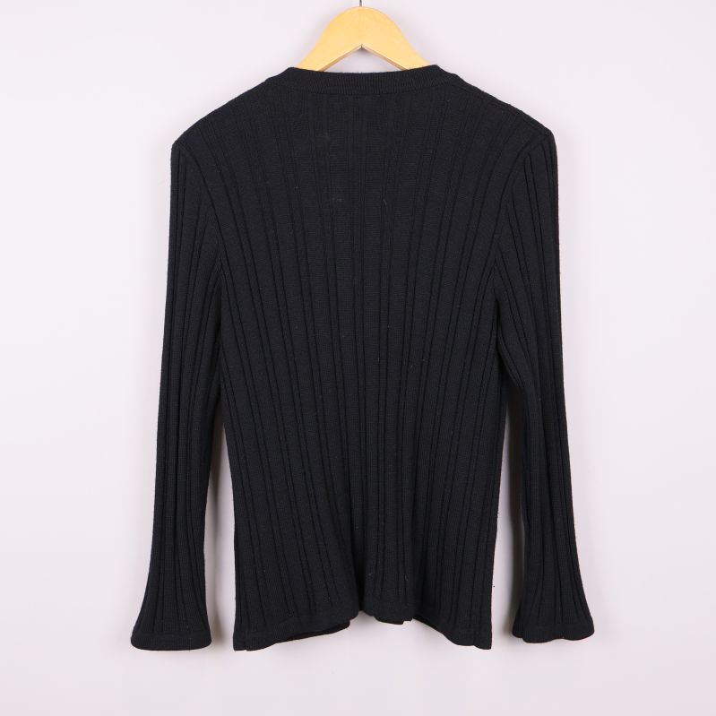 Baksidan av svart ribbstickad kofta på galge