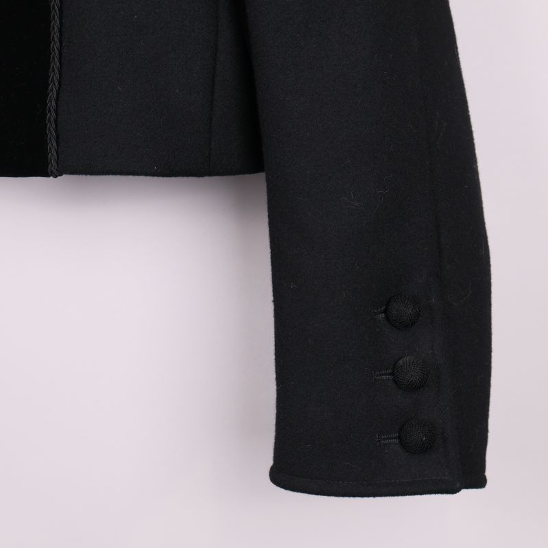 Ärmslut med tre tygklädda knappar på svart jacka