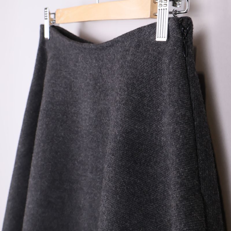 Närbild på övre del av vid grå kjol och dragkedja