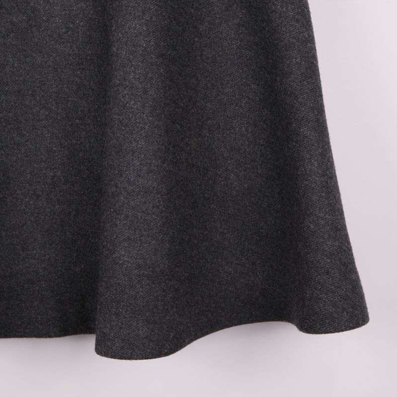 Närbild på nederkant av vid grå kjol