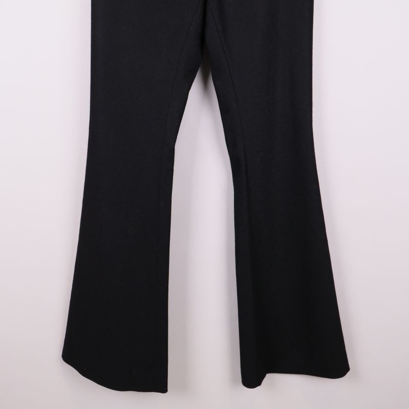 Utsvängda ben på svart byxa i närbild