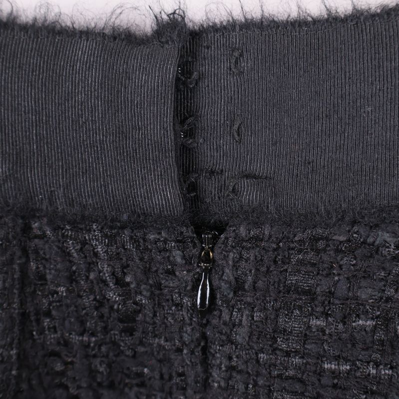 Närbild på bakre dragkedja och hake i midjan