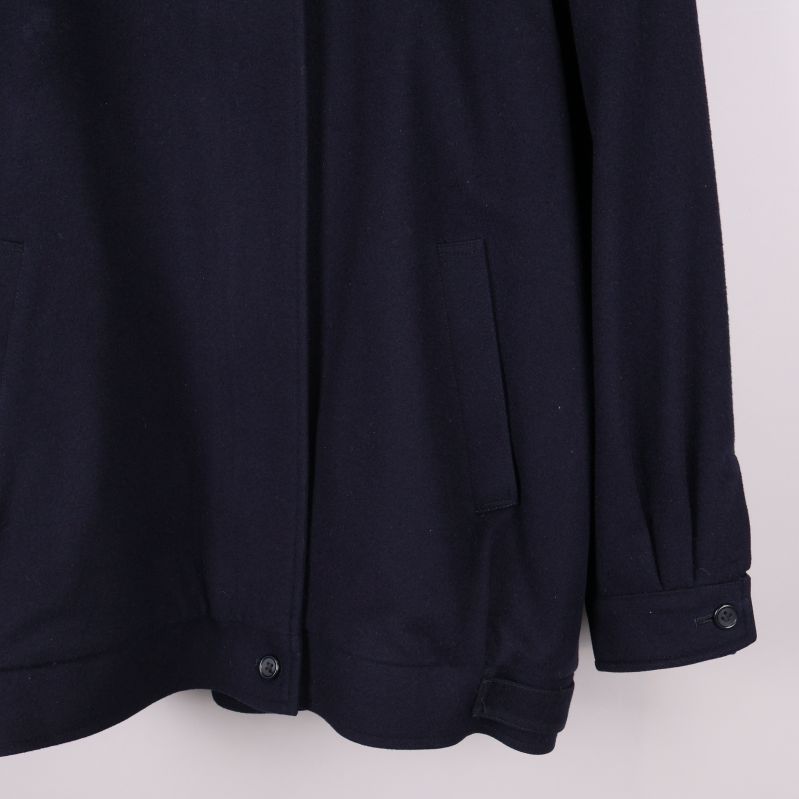 Närbild på ena ärmfickan och manschettknapp på jacka