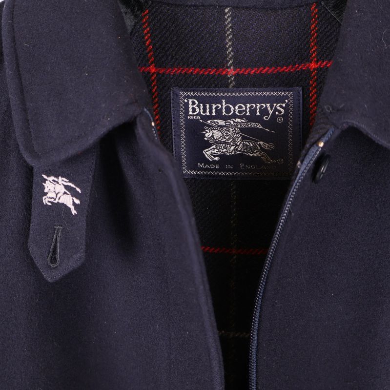 Närbild på Burberrys logotyp och rutigt innerfoder