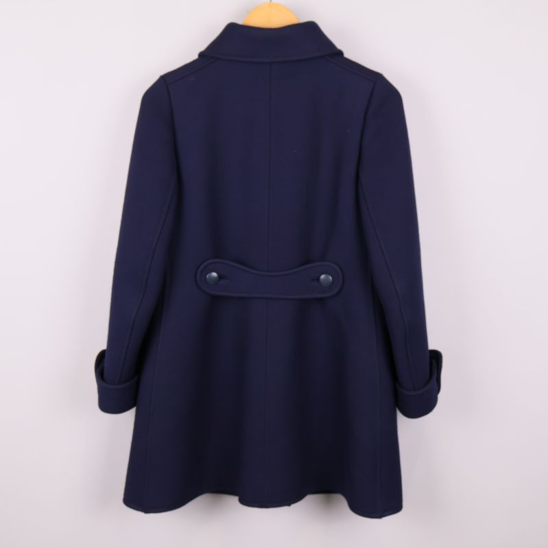 Baksidan av marinblå kappa med knäppt detalj i midjan